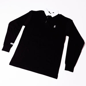 image of a black long sleeve rugby shirt with a white collar on a white background. small white anchor with a heart on the right chest area. small rectangle patch on left sleeve that says bouncing souls